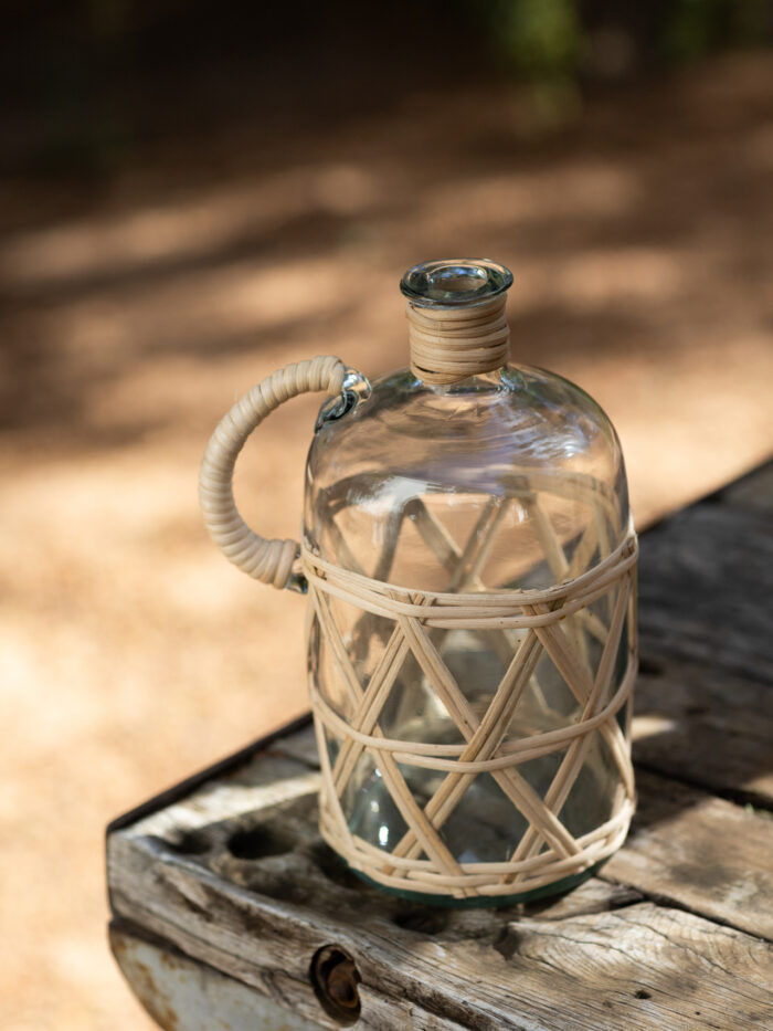 Glass bottle with rattan wrapped handle